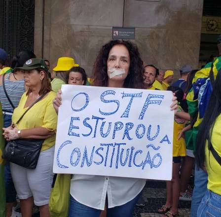 Andrea Richa aparece em meio a manifestação bolsonarista segurando um cartaz com a mensangem "O STF estuprou a Constituição"