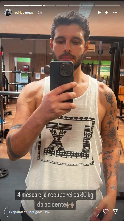 Foto retirada dos Stories do ex-BBB Rodrigo Mussi em que ele aparece de regata na academia em selfie no espelho e escreve: "Quatro meses e já recuperei os 30kg do acidente"