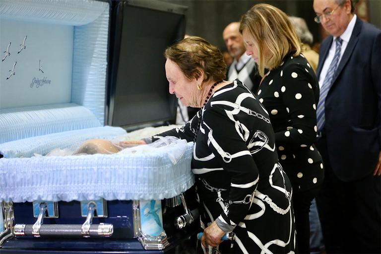 Mãe de Gugu Liberato surge comovida ao lado do corpo do filho