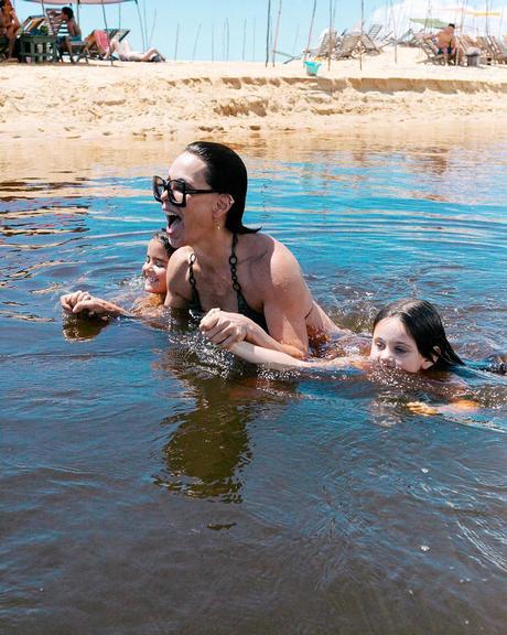 Em viagem à Bahia, Carolina Ferraz se refresca em rio com a filha caçula