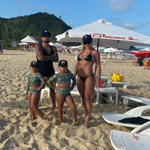 Dentinho posa com a esposa, Dani Souza e os filhos em dia de praia