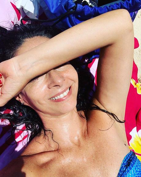 Claudia Ohana posa com a cara no sol em dia de praia e seguidores elogiam