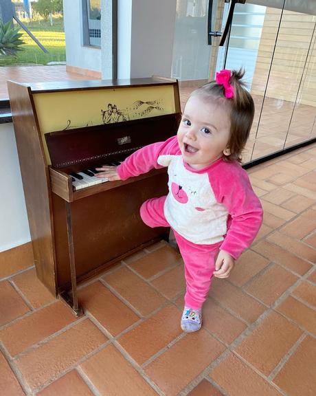 Filha de Thaeme Mariôto se diverte ao aprender a tocar piano